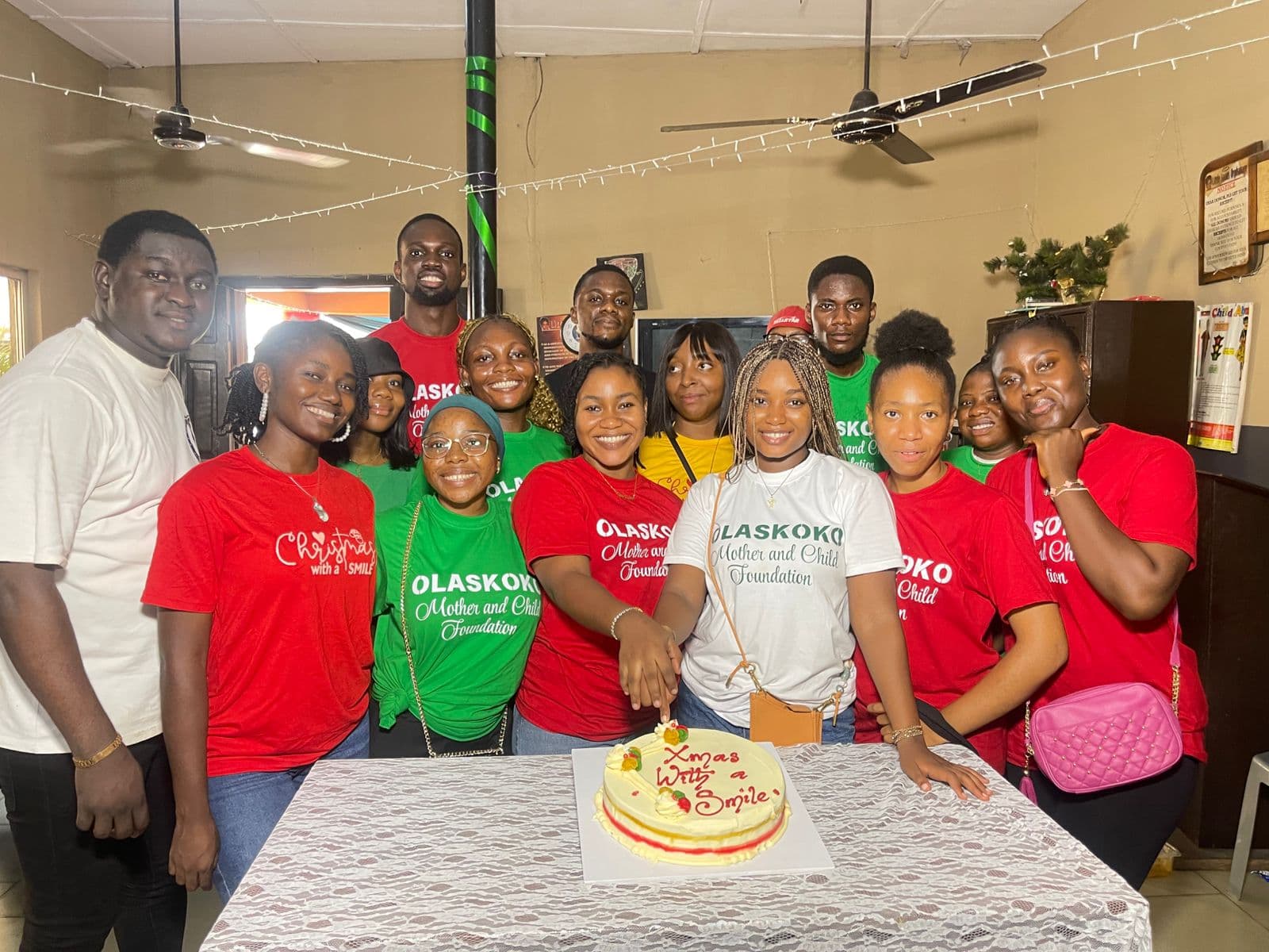 The Olaskoko team gathered around a Christmas With A Smile cake